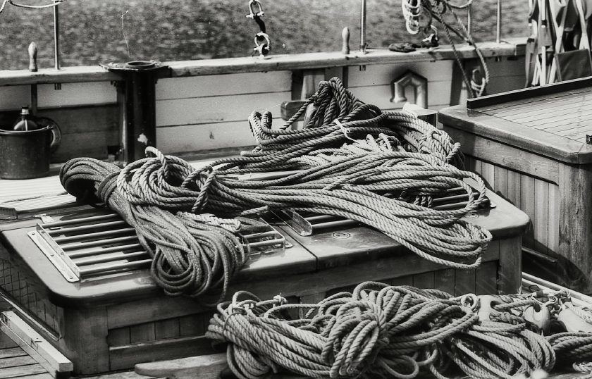 Aufgerollte Schiffstaue auf einem Holzdeck